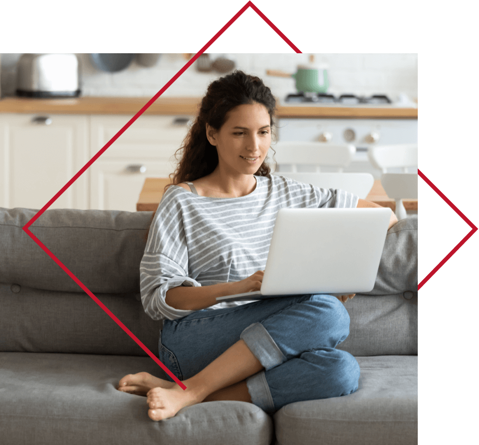 Woman sitting on couch using laptop.