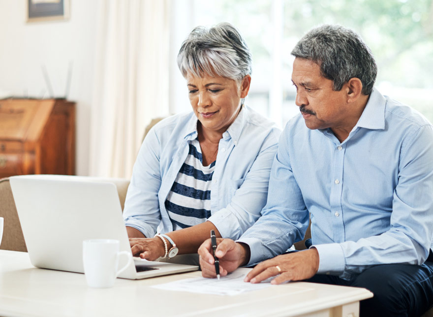 Husband and wife looking at their Easthigh Credit Union account on the computer together.